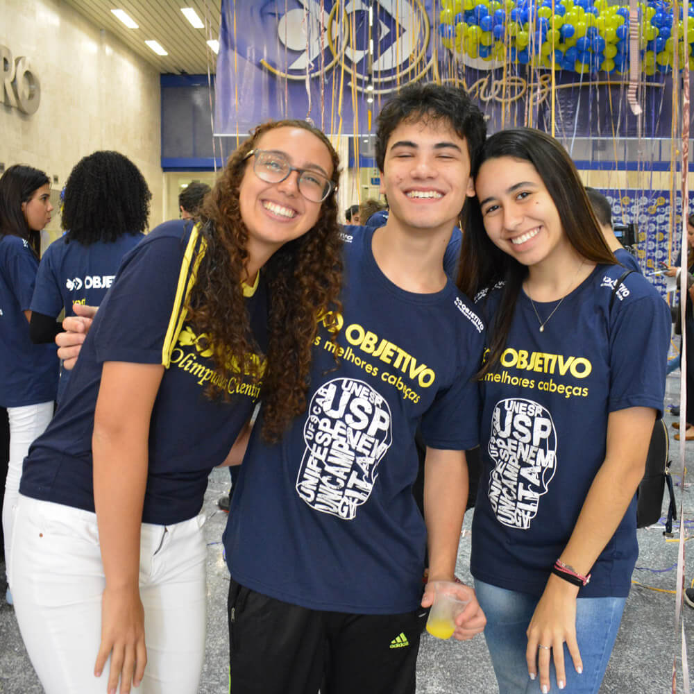 Foto de alunos do Objetivo comemorando a aprovação no vestibular.